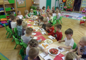 dzieci na papierowych talerzykach układają wzory z kuleczek czekoladowych