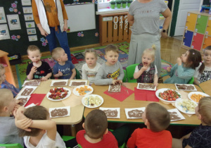 dzieci na papierowych talerzykach układają wzory z kakaa