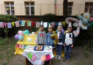 7-letni Solenizanci na tle dekoracji urodzinowej
