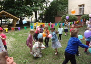 dzieci w ogrodzie przedszkolnym podczas zabawy urodzinkowej z balonami