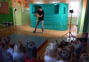Dzieci uważnie oglądają spektakl prowadzony przez aktora Teatrzyku "WidziMiSię"