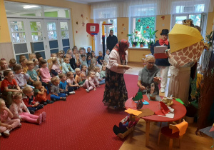 Przedszkolaki z uśmiechem na twarzy oglądają spektakl przygotowany przez pracowników przedszkola.