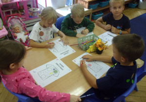 Grupa dzieci pracuje przy stoliku.