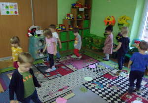 Dzieci maszerują po dywanie.