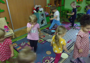 Dzieci biegają po dywanie.