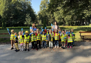 Żaczki z Panią Dominiką i Panią Marysią w parku pokazują swoje rękawiczki.