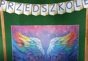 Plakat z kolorowymi skrzydłami.