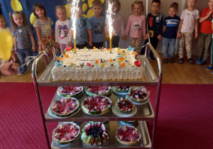 Tort z zapalonymi świeczkami.