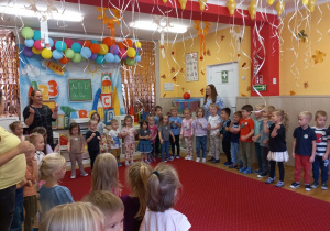 Przedszkolaki naśladują ruchy pokazywane przez Panią Karolinę.