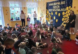Przedszkolaki bawią się na dywanie.