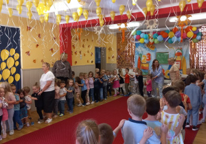 Przedszkolaki wraz z pracownikami przedszkola ustawieni w "pociąg".
