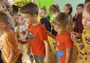 Przedszkolaki przebrani w kolory jesieni tańczą.