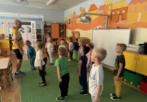 Żaczki stoją prosto z rękoma spuszczonymi w dół ciała, naśladują ruchy Pana prowadzącego karate.