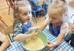 Dziewczynka miesza ciasto na pączki.