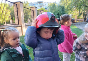 Chłopiec w hełmie strażackim.