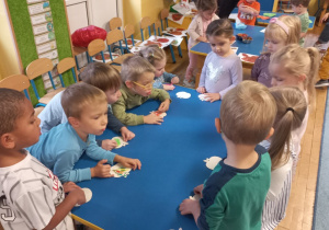Dzieci kolorują drewniane jabłka.