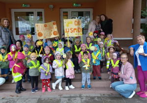 Zdjęcie grupowe z plakatem grupy Smyków i Tuptusiów z Paniami.