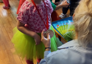 Pani Agnieszka zakłada dziewczynce medal.