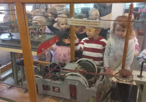 Tuptusie przyglądają się modelom starych wagonów.