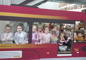 Dzieci pozują przy modelu tramwaju.