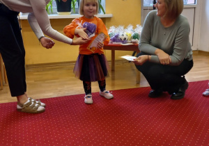 Dziewczynka odbiera nagrodę od Pani Dyrektor.