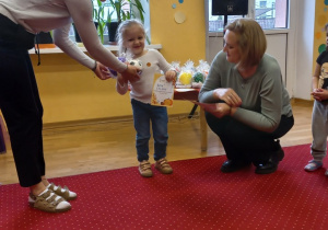 Dziewczynka odbiera nagrodę od Pani Dyrektor.
