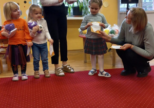 Dziewczynka odbiera nagrodę od Pani Dyrektor.