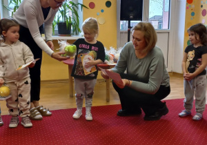 Dziewczynka odbiera nagrodę od Pani Dyrektor.