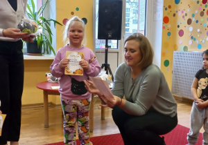 Dziewczynka odbiera nagrodę od Pani Dyrektor.