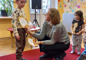 Chłopiec odbiera nagrodę od Pani Dyrektor.