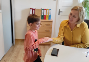 Chłopiec odbiera nagrodę od Pani Dyrektor.