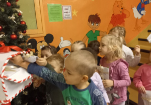 Chłopiec wrzuca do skrzynki list do Świętego Mikołaja.