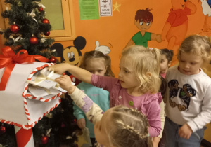 Dziewczynki wrzucają do skrzynki listy do Świętego Mikołaja.