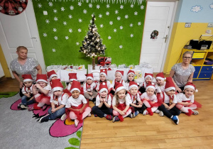 Zdjęcie grupowe Tuptusiów na tle choinki.