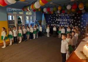 Juniorzy stoją na świątecznym tle.