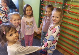 Dziewczynki tańczą w kole.