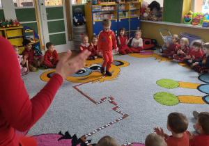 Chłopiec przechodzi przez trasę ułożoną z brązowego papieru i kolorowych serduszek.