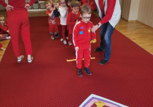 Chłopiec rzuca woreczkiem do serduszka.