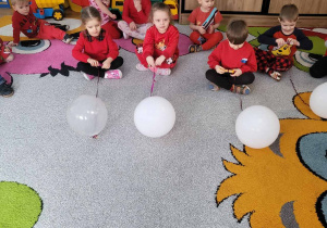 Tuptusie w zabawie kto szybciej przyciągnie balon.