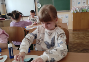 Dziewczynka przykleja popcorn.