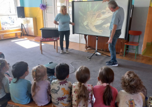 Tuptusie przyglądają się wyświetlanemu na projektorze zwierzątku.