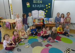 Dzieci pozują przed dekoracją z ksiażkami.
