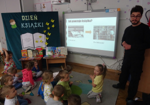 Dzieci oglądają prezentację i słuchają o książkach.
