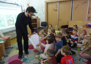 Dzieci dotykają kartek książki.