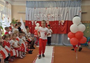 Chłopiec idzie wzdłuż sali.