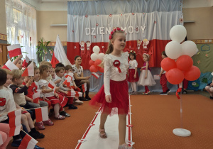 Inna dziewczynka idzie wzdłuż sali.