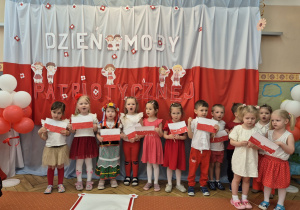 Grupa dzieci stoi razem obok siebie.