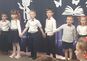Dzieci trzymają się za ręce i śpiewają.