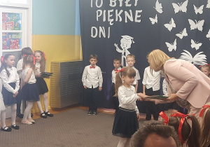 Pani Dyrektor wręcza książkę dziewczynce.