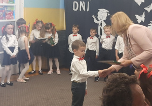 Pani Dyrektor wręcza książkę chłopcu.